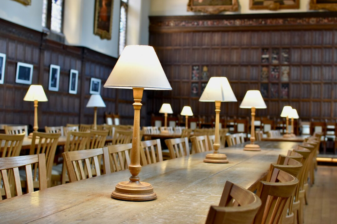 Historic archive reading room with long wooden tables and brass lamps